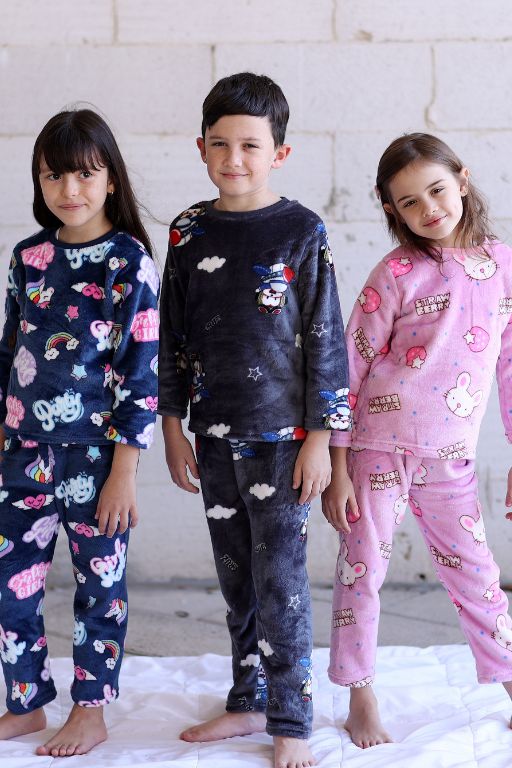 שלושה ילדים עומדים שתי בנות ובן לובשים פיגמה כחולה וורודה עם ציור חיות