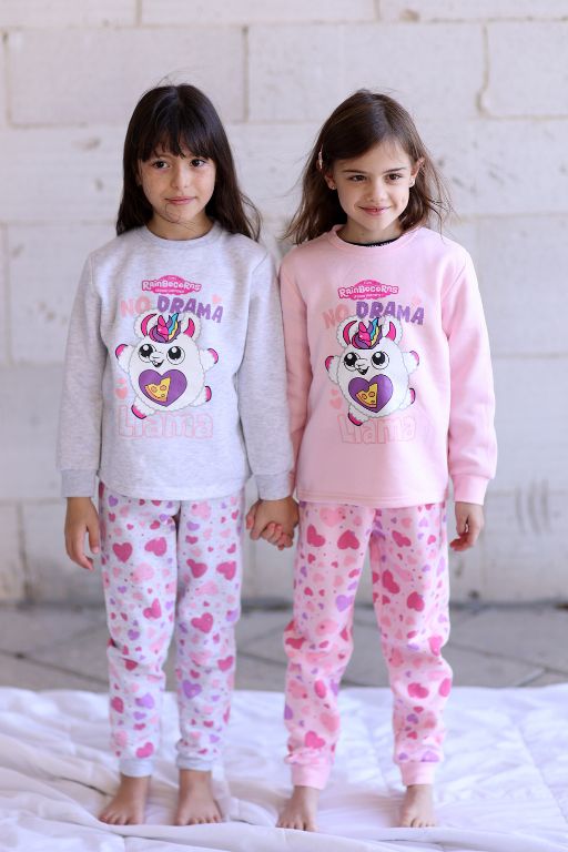 שתי ילדות עומדות לובשות פיג'מות ורודה ולבנה עם ציור של דמות עם לב