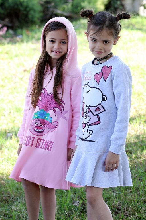 שתי ילדות עומדות לובשות שמלה אפורה וורודה הדפס של כלב וטרול